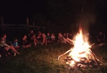 Familii stând la foc de tabară