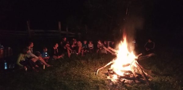 Familii stând la foc de tabară