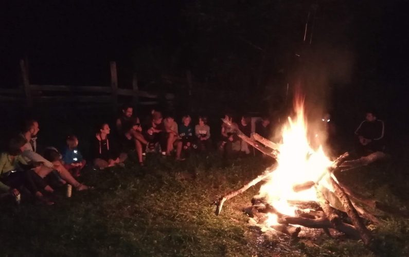 Familii stând la foc de tabară